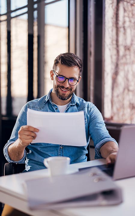 Photo of man in coffee shop reading a page